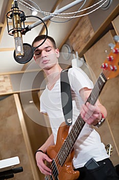 Young bass player standing with his guitar