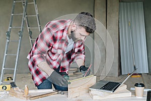 Young bearded businessman, builder, repairman, carpenter, architect, designer, handyman dressed in plaid shirt