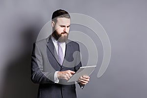 Young bearded businessman using tablet computer