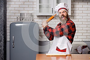 Young bearded chef angry or banging on someone on kitchen.