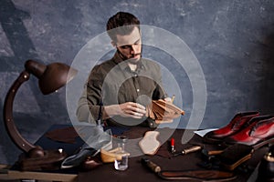 Young bearded cobber holding a set of cloth