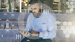 Young bearded hipster man sits and uses digital tablet. In foreground are virtual icons with people, digital gadgets.