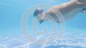 Young bearded man is diving in swimming pool in his vacation on tropical island.