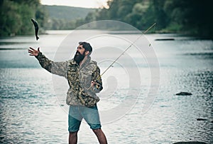 Young bearded man fishing at a lake or river. Flyfishing. photo