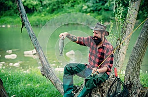 Young bearded man fishing at a lake or river. Flyfishing. photo