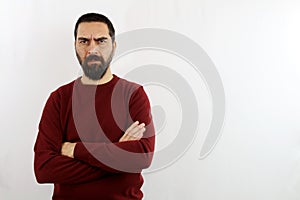 Young bearded man on isolated white background with serious face and crossed arms