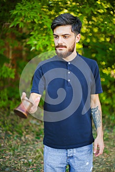 Young bearded man juggles with the coffee kettle.