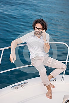 Young bearded man on a luxury yacht with a magnificent view of the sea.