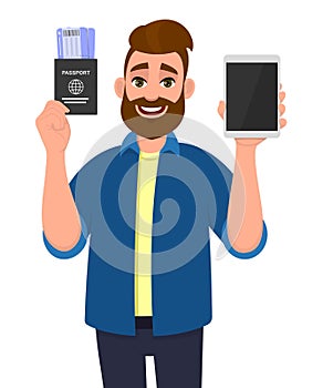 Young bearded man showing passport with tickets and blank screen tablet computer. Hipster trendy person holding boarding pass and