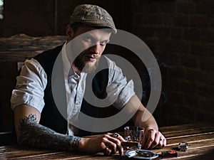 A young bearded man smoking a cigar in a pub