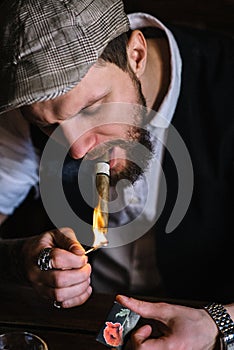 A young bearded man smoking a cigar in a pub