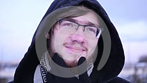 Young bearded man thinking about something and touching his beard