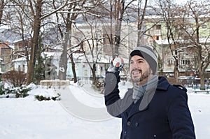 Young bearded man throwing a snowball