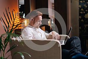 Young bearded man using laptop working from home in internet.