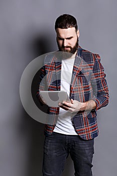 Young bearded man using tablet computer
