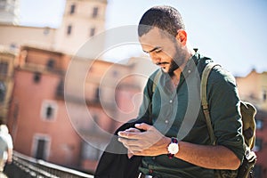 Young bearded traveller using his smartphone