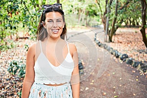 Young beatiful woman smiling happy and cheerful at green park on a sunny day of summer