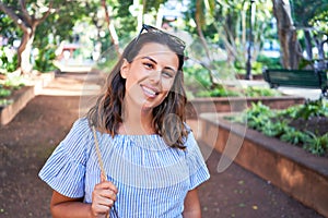 Young beatiful woman smiling happy and cheerful at green park on a sunny day of summer