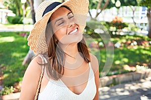 Young beatiful woman smiling happy and cheerful at green park on a sunny day of summer