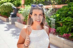 Young beatiful woman smiling happy and cheerful at green park on a sunny day of summer