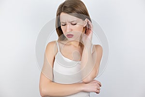 Young beatuiful blond woman looks upset standing alone on isolated white background, melancholic mood
