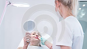 The young beautician doctor preparing to making injection in female lips. The doctor cosmetologist makes lip augmentation