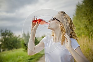 Young beautifil woman drinking red softdrink.