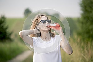 Young beautifil woman drinking red softdrink.