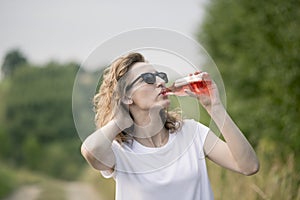 Young beautifil woman drinking red softdrink.