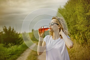 Young beautifil woman drinking red softdrink.