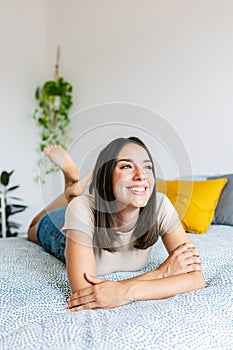 Young beautiful adult woman daydreaming on bedroom.