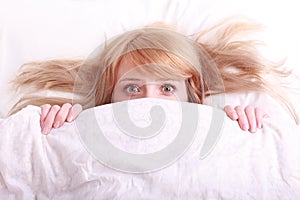 Young beautiful afraid woman in bed