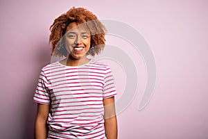 Young beautiful African American afro woman with curly hair wearing casual striped t-shirt with a happy and cool smile on face