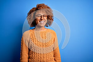 Young beautiful African American afro woman with curly hair wearing casual sweater with a happy and cool smile on face
