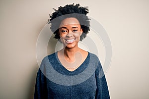 Young beautiful African American afro woman with curly hair wearing casual sweater with a happy and cool smile on face