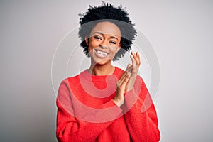 Young beautiful African American afro woman with curly hair wearing red casual sweater clapping and applauding happy and joyful,