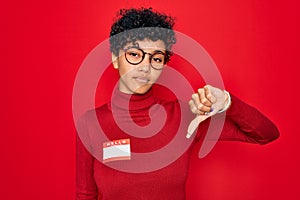 Young beautiful african american afro woman using sticker with presentation message with angry face, negative sign showing dislike