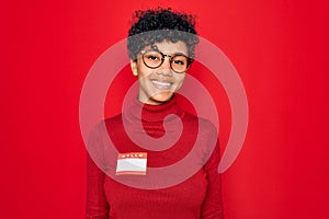 Young beautiful african american afro woman using sticker with presentation message with a happy face standing and smiling with a