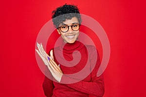 Young beautiful african american afro woman wearing turtleneck sweater and glasses clapping and applauding happy and joyful,