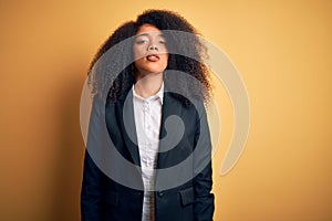 Young beautiful african american business woman with afro hair wearing elegant jacket Relaxed with serious expression on face