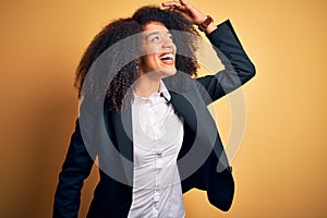 Young beautiful african american business woman with afro hair wearing elegant jacket very happy and smiling looking far away with