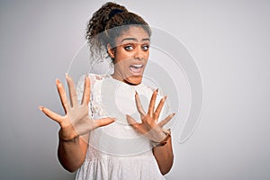 Young beautiful african american girl wearing casual t-shirt standing over white background afraid and terrified with fear