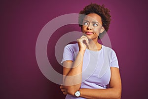 Young beautiful african american woman with afro hair over isolated purple background with hand on chin thinking about question,