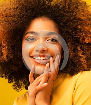 Young beautiful african american woman face close up teeth smile happy positive emotion.