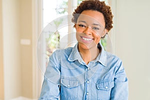 Young beautiful african american woman looking away to side with smile on face, natural expression