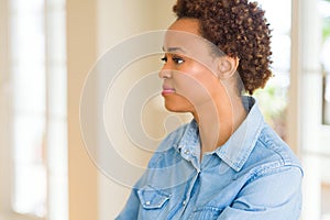 Young beautiful african american woman looking to side, relax profile pose with natural face with confident smile