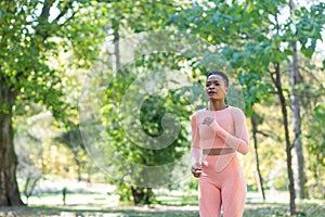 Young beautiful african american woman on a morning jog in the autumn park