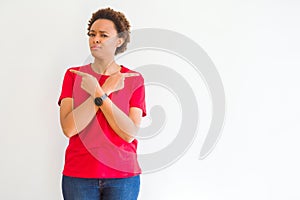 Young beautiful african american woman over white background Pointing to both sides with fingers, different direction disagree