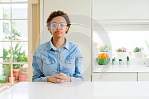 Young beautiful african american woman wearing glasses with serious expression on face