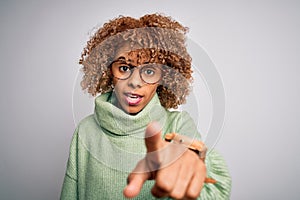 Young beautiful african american woman wearing turtleneck sweater and glasses pointing displeased and frustrated to the camera,